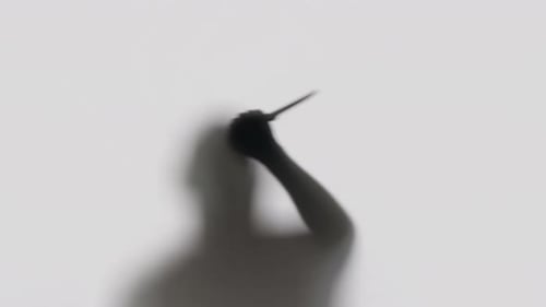 Silhouette of Person Threatening with Knife