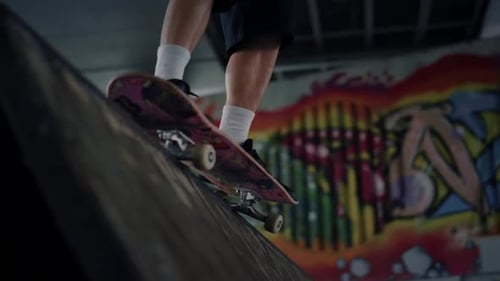 Active Man Practicing Skateboard at Skate Park with Graffiti on Wall