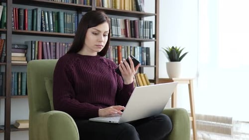 Casual Sitting Woman Using Smartphone and Laptop for Work