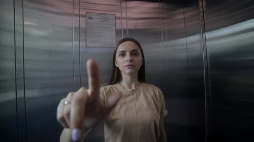 Woman Interacting with Virtual Interface in Elevator