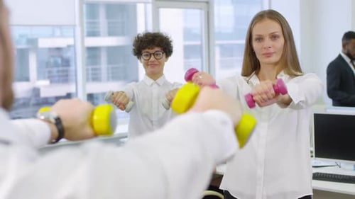 Three Caucasian Office Workers Using Dumbbells