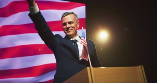 Man Giving Speech with American Flag Behind Him