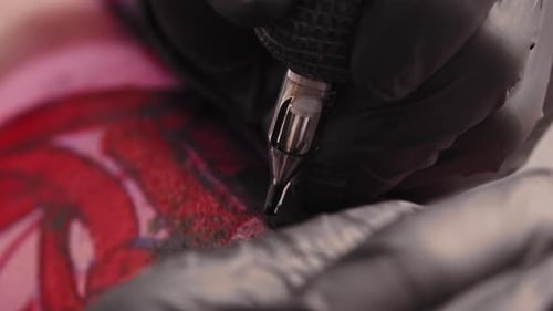 Close Up of Tattoo Artist Inking Red Design