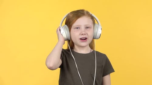 Excited Young Girl Listening to Music on Headphones