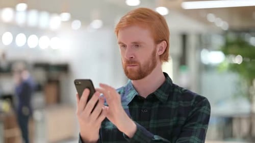 Adult with Red Hair Using a Smartphone
