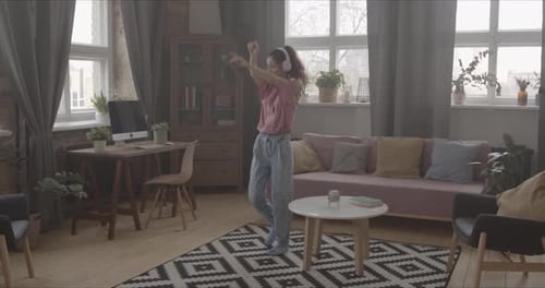 Carefree Woman Dancing to Music at Home