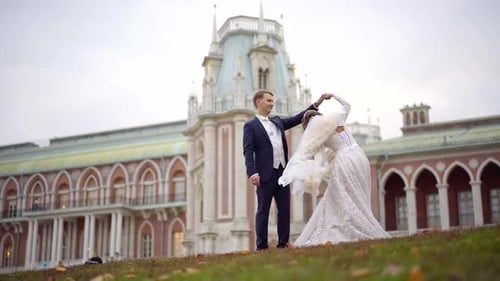 Cheerful and Rejoicing Newlyweds Are Dancing Near Restaurant in Autumn Day