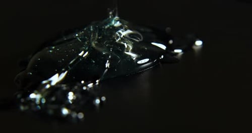 Pouring Transparent Liquid on Black Background