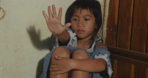 Young Child Raising Hand to Stop, Close-Up Indoors