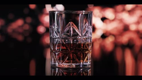 Crystal Glass with Brown Liquid and Bokeh Background