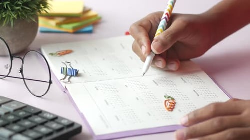 Young Man Hand Marking on a Calendar Date