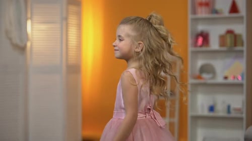 Adorable petite fille dansant en robe rose, se faisant passer pour une princesse, bonheur
