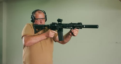 Man Practices Firing Rifle at Indoor Shooting Range