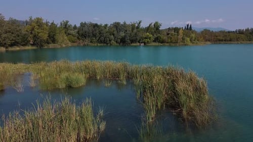 Aerial view over a beautiful landscape with a natural lake, its calm turquoise water surrounded by w