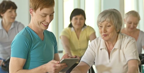 Woman on Exercise Bike with Personal Trainer