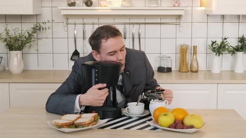 Man in Suit Hugs and Drinks Coffee