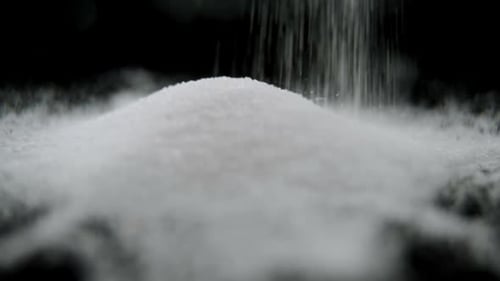 Sugar falling on black background