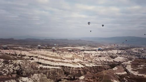 View of Valley with Sandstone Hills Next to Ancient City with Uchisar Castle and Flying Balloons