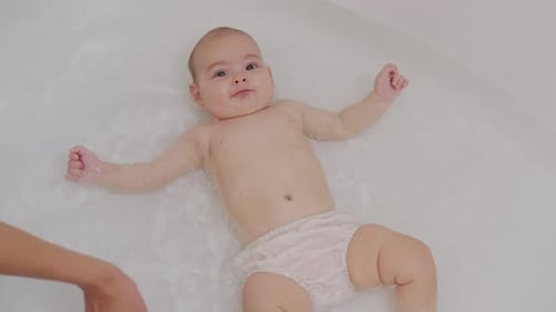 Top View of Funny Newborn Baby Swimming During Bathing