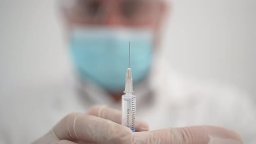 Medical Professional Prepares Hypodermic Needle for Injection