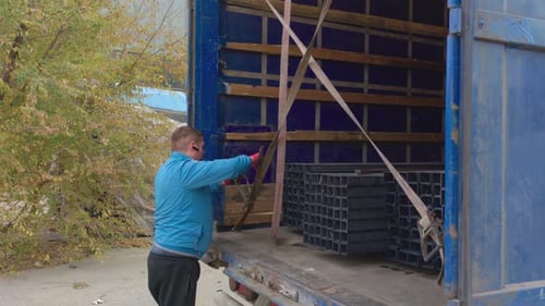Man Securing Metal in Truck for Transport