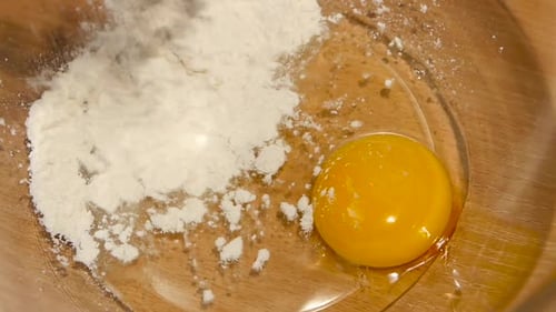 Wheat Flour Is Added To Plate with Egg. Slow Motion