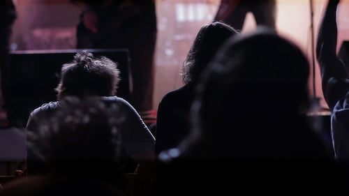 Silhouetted Crowd Watching Live Band Performance at Night