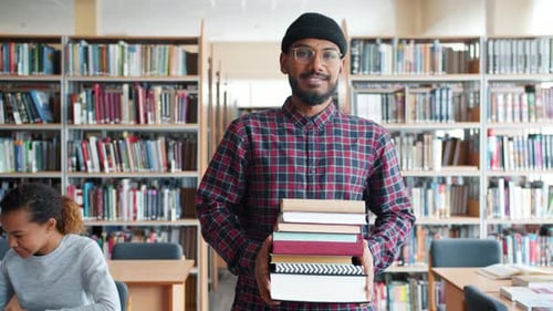 Slow Motion of Handsome African American Student Walking in Library with Books