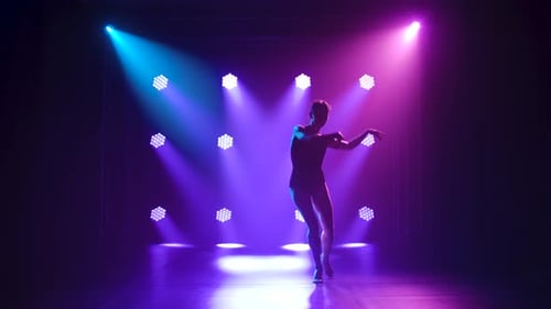 Woman dancing in a studio with blue and magenta lights