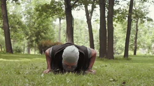 Man With Grey Beard Doing Pushups In Park