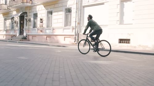 Cyclist Man Riding Fixed Gear Sport Bike in Sunny Day on a City