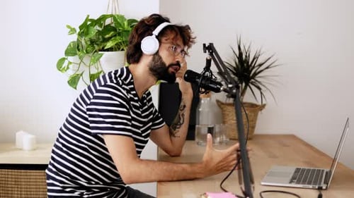 Young Adult Hipster Content Creator Man Streaming Podcast Online at Home Studio