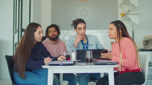 Des amis multiraciaux se détendent dans la cuisine après des
