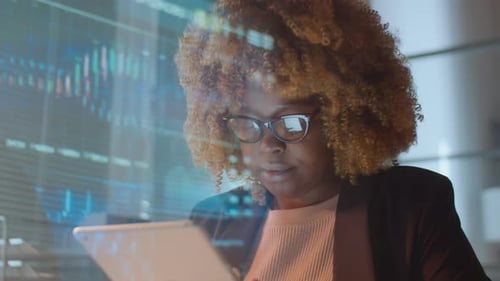 African American Woman Working on Tablet in Office at Night
