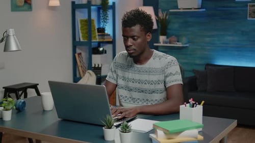 Young Adult Working on Laptop at Desk