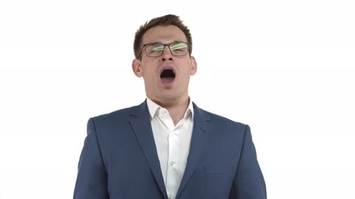 Schöner männlicher Unternehmer in blauem Anzug und Brille fühlt sich müde, gähnt und bedeckt den geöffneten Mund