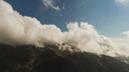 Mountains Partially Obscured By Clouds Against Blue Sky
