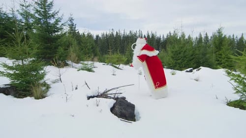 Père Noël marchant dans une forêt enneigée