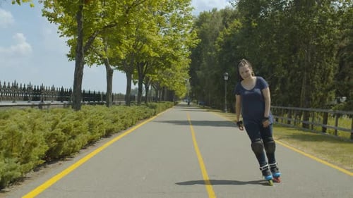 Woman Roller Skating in a Green Park on Sunny Day