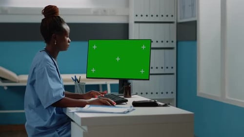 Asistente médico con pantalla verde horizontal en la computadora