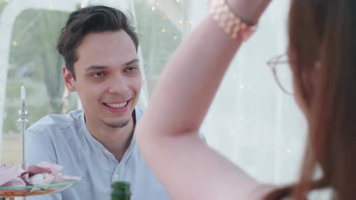 Smiling Couple Enjoying Intimate Meal in Lighted Tent