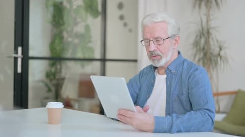 Senior Old Man Making Video Call on Tablet in Office