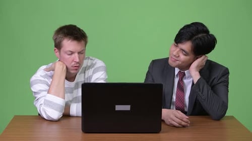 Two Men Looking at Laptop Together at Work