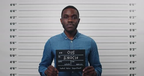 Portrait of Afro American Male Person Holding Sign for Photo in Police Department