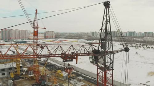 Gran grúa de construcción naranja en un edificio inacabado