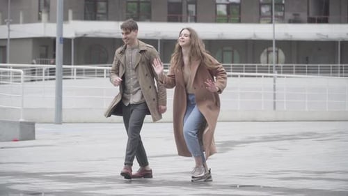 Wide Shot of Cheerful Young Couple Dancing Outdoors on Urban City Street. Portrait of Positive