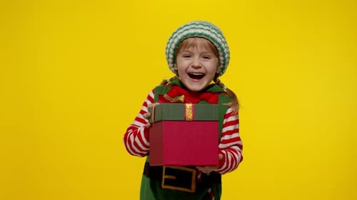 Happy Child Receiving Christmas Present in Elf Costume