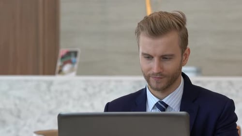 smart handsome caucasian businessman in suit work and communication with laptop and smartphone
