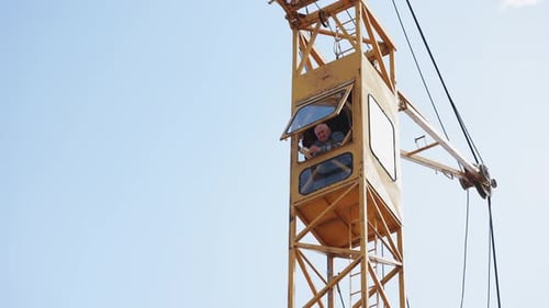 Ouvrier dans le poste de pilotage d'une grue