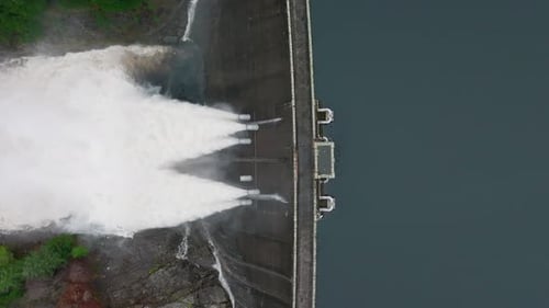 Wasser wird durch einen durch Schwerkraft gespeisten Wasserkraftwerk-Damm gepumpt